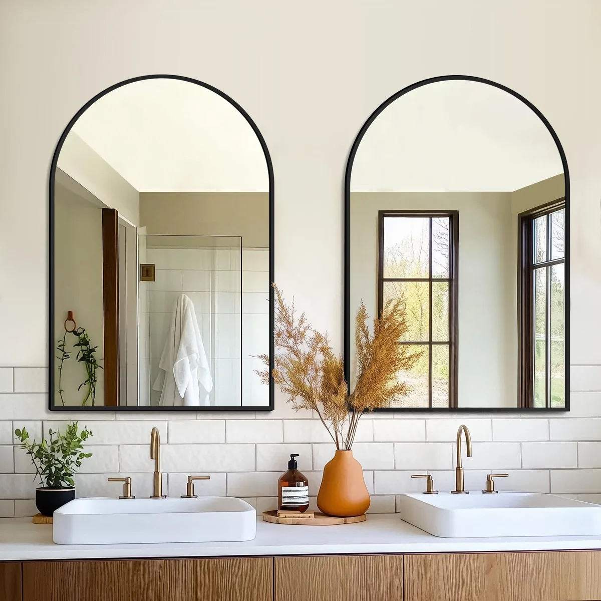 Two black arched mirrors 24 by 36 inches in metal frames