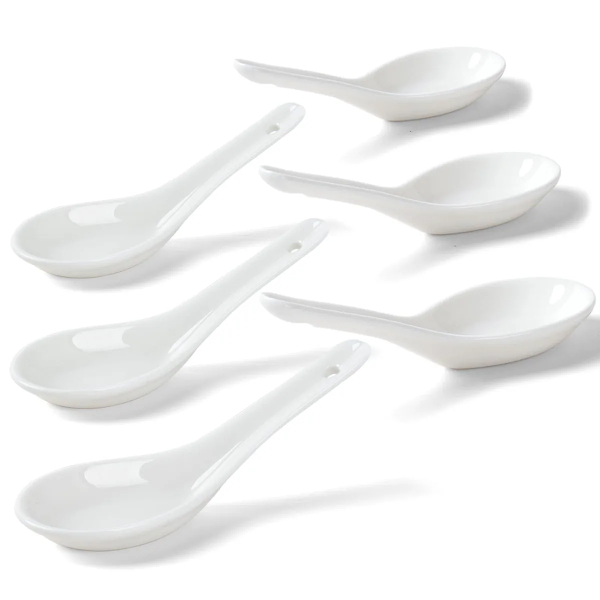Sixteen white ceramic soup spoons in a box