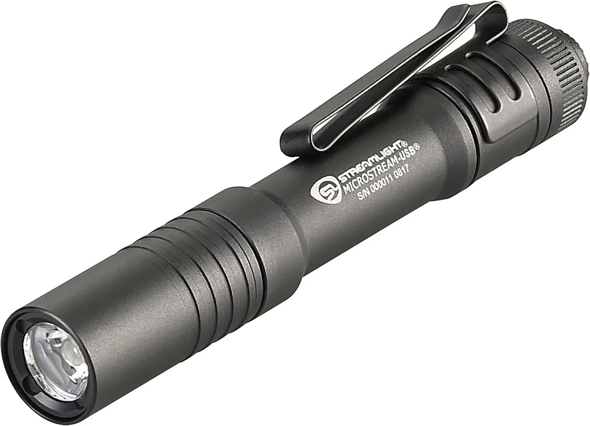 Black ultra-compact flashlight with metal charging sleeve and pocket clip