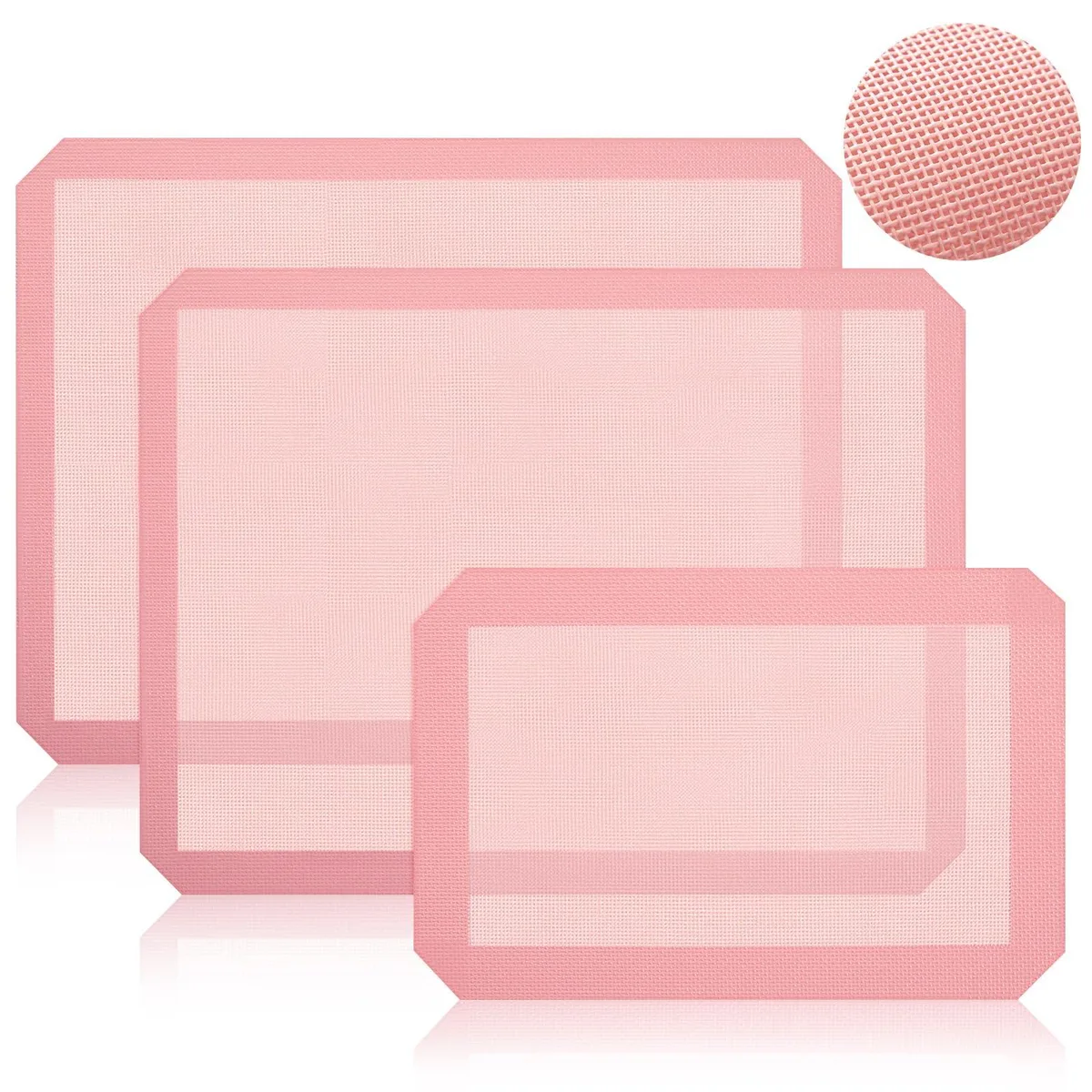 Three pink perforated silicone baking mats, two half-sheet and one quarter-sheet