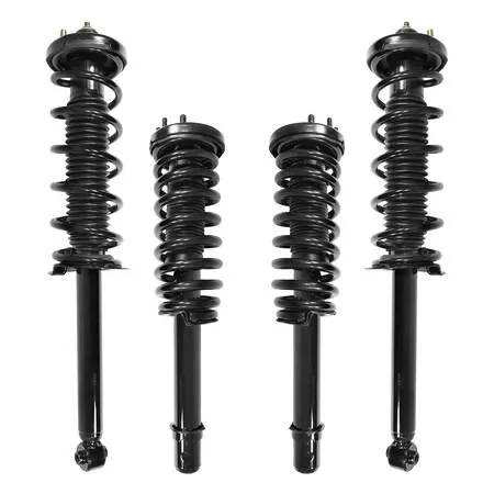 Four silver strut assemblies with black coil springs on grey surface