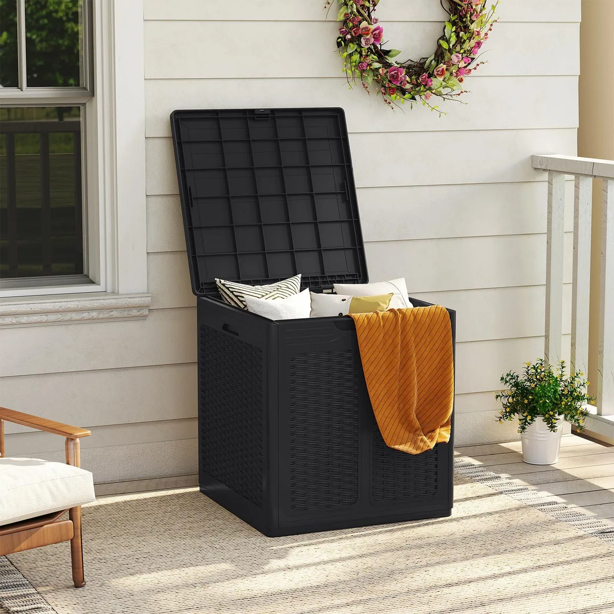 Black rectangular outdoor storage box with woven rattan texture, hinged lid and side handles, 39 gallon capacity