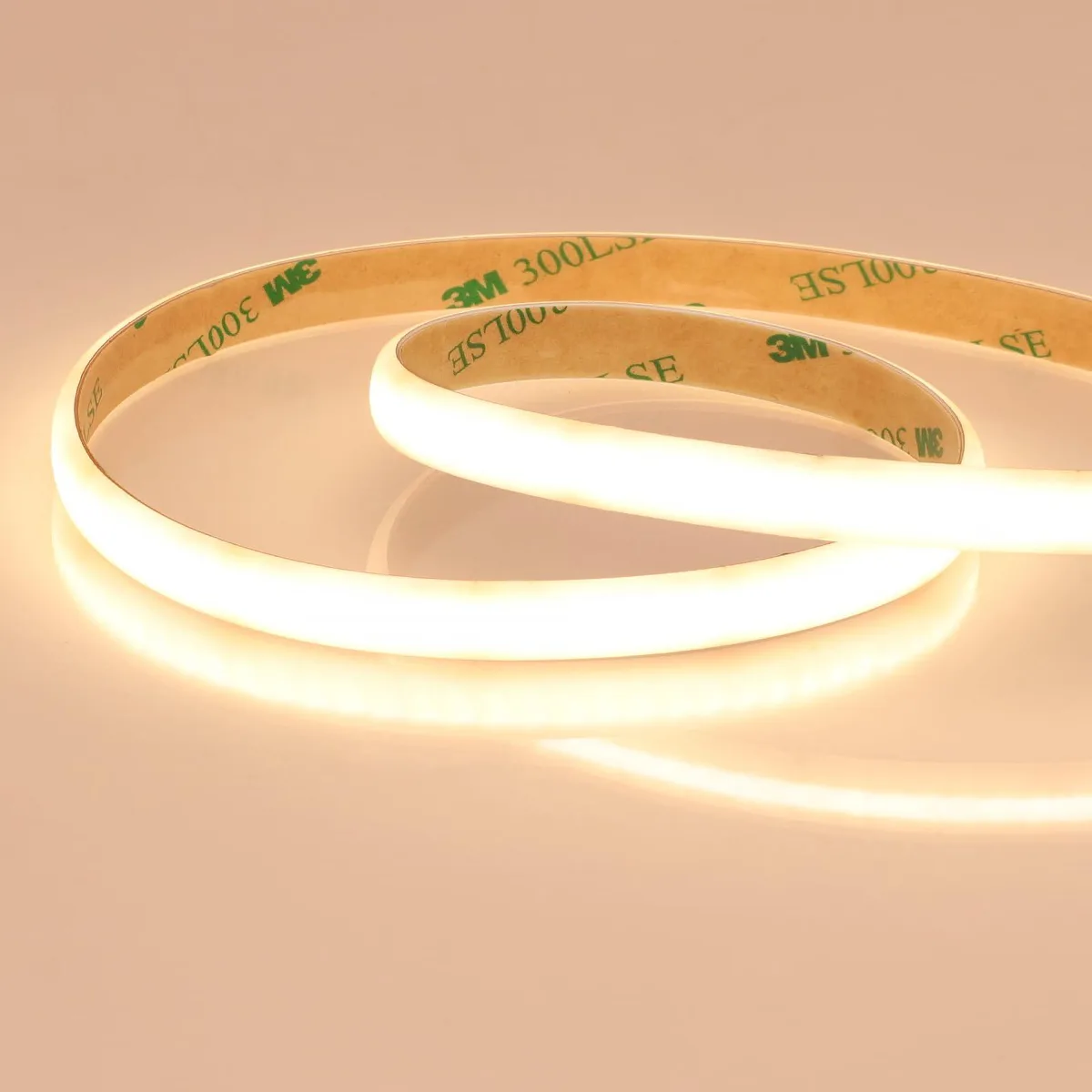 A 16.4 foot white diffused COB LED strip on a reel, milky silicone coating hiding the diodes, 0.39 inch wide and 0.11 inch high