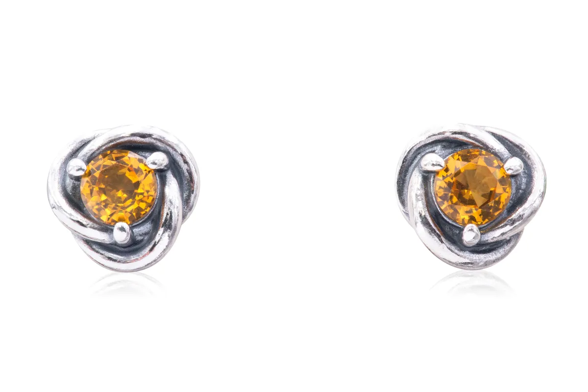 Pair of silver-tone stud earrings with infinity braid design and honey-colored crystal centers