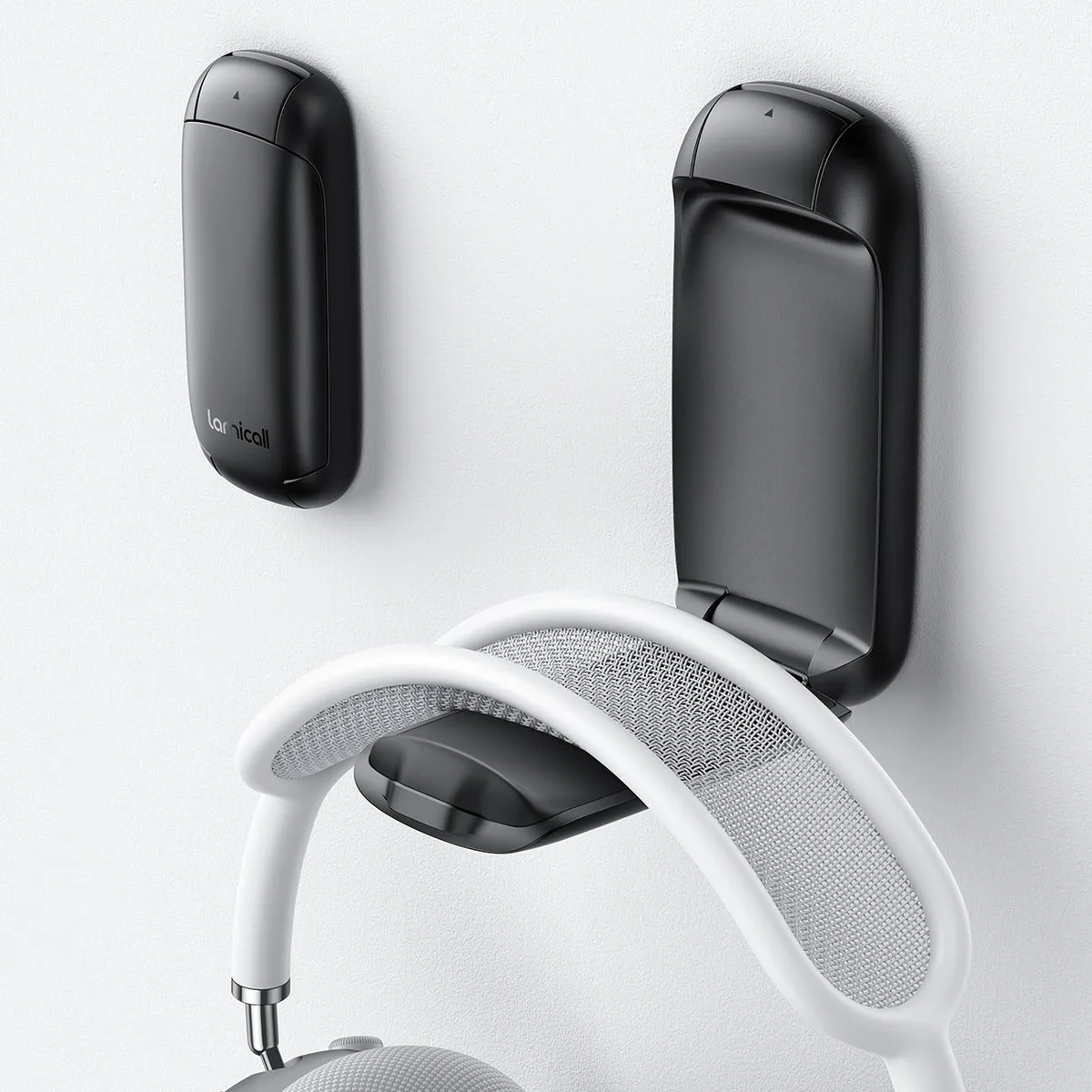 Black foldable headphone stand with silicone-padded arms and adhesive mount