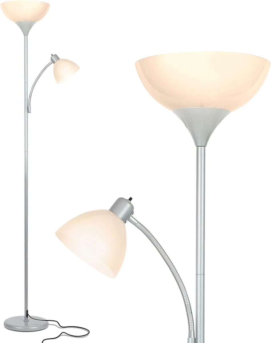 Silver floor lamp with weighted base and dual LED heads emitting warm white light
