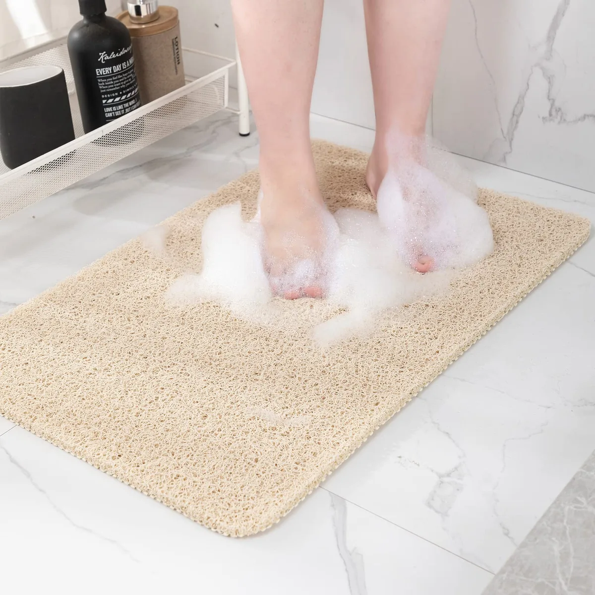Beige rectangular PVC bath mat with drain holes and textured surface, 24 by 16 inches