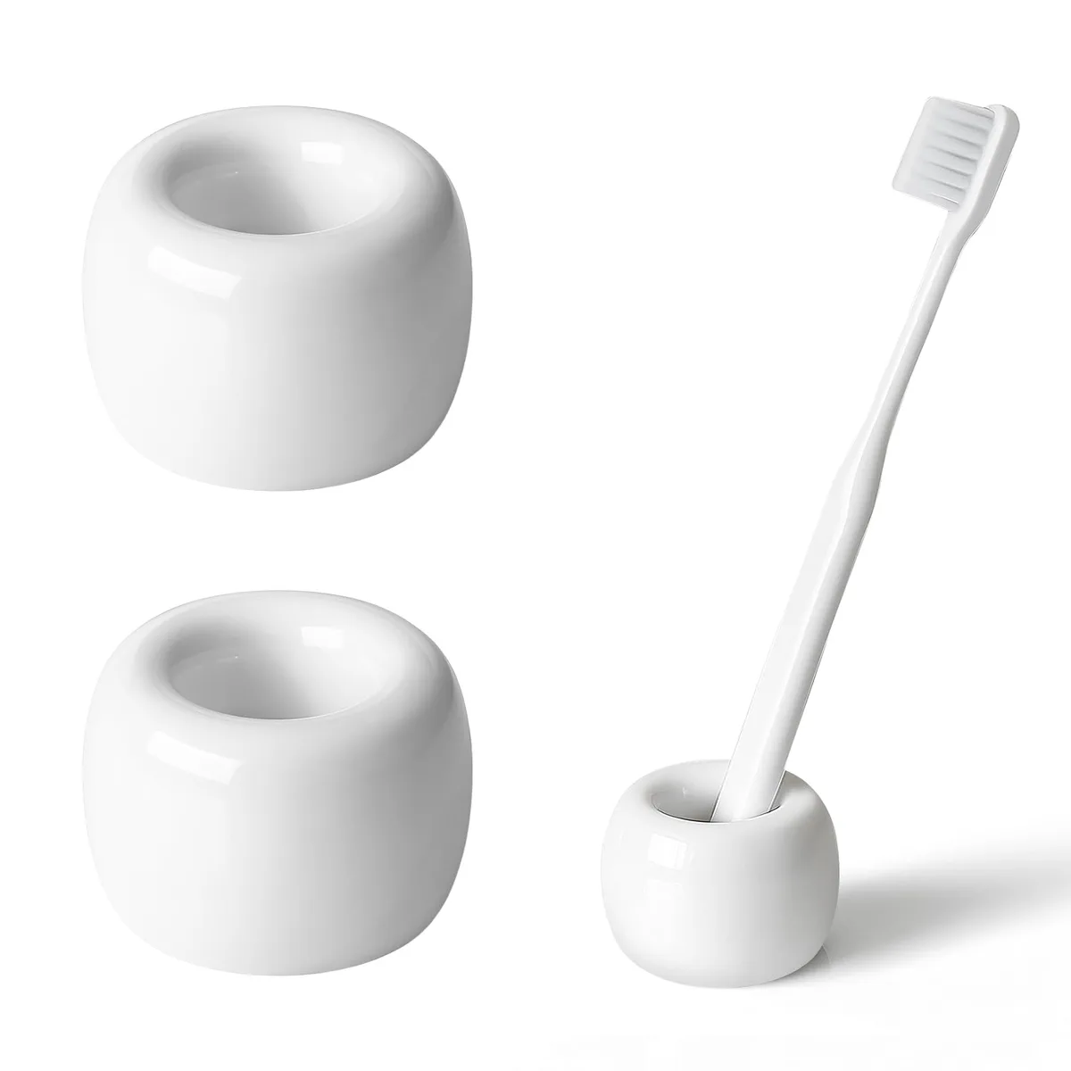 Two small white ceramic toothbrush holders with glossy finish and textured bases