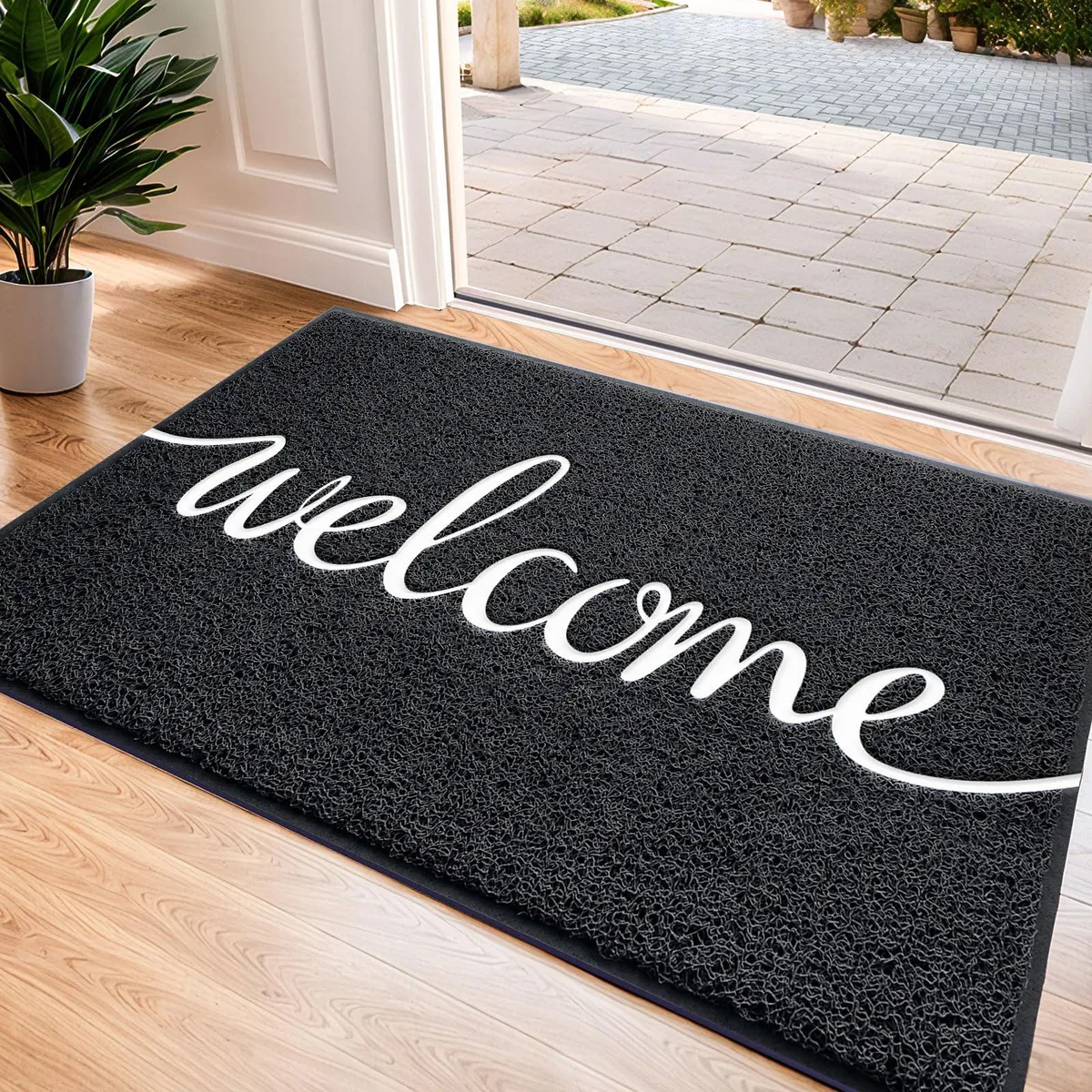 Black rectangular door mat with embossed WELCOME text low-profile non-slip backing