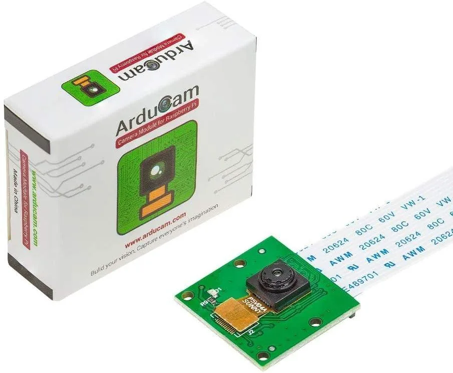 Small green circuit board with a silver camera lens and ribbon cable attached