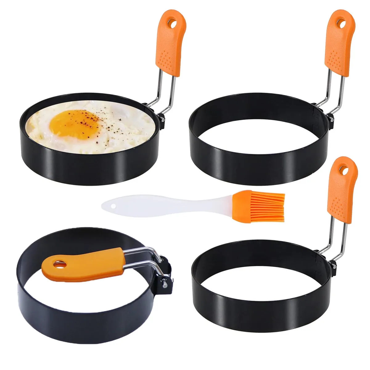 Four stainless steel egg rings 3.5 inch diameter .8 inch deep with silicone handles and oil brush