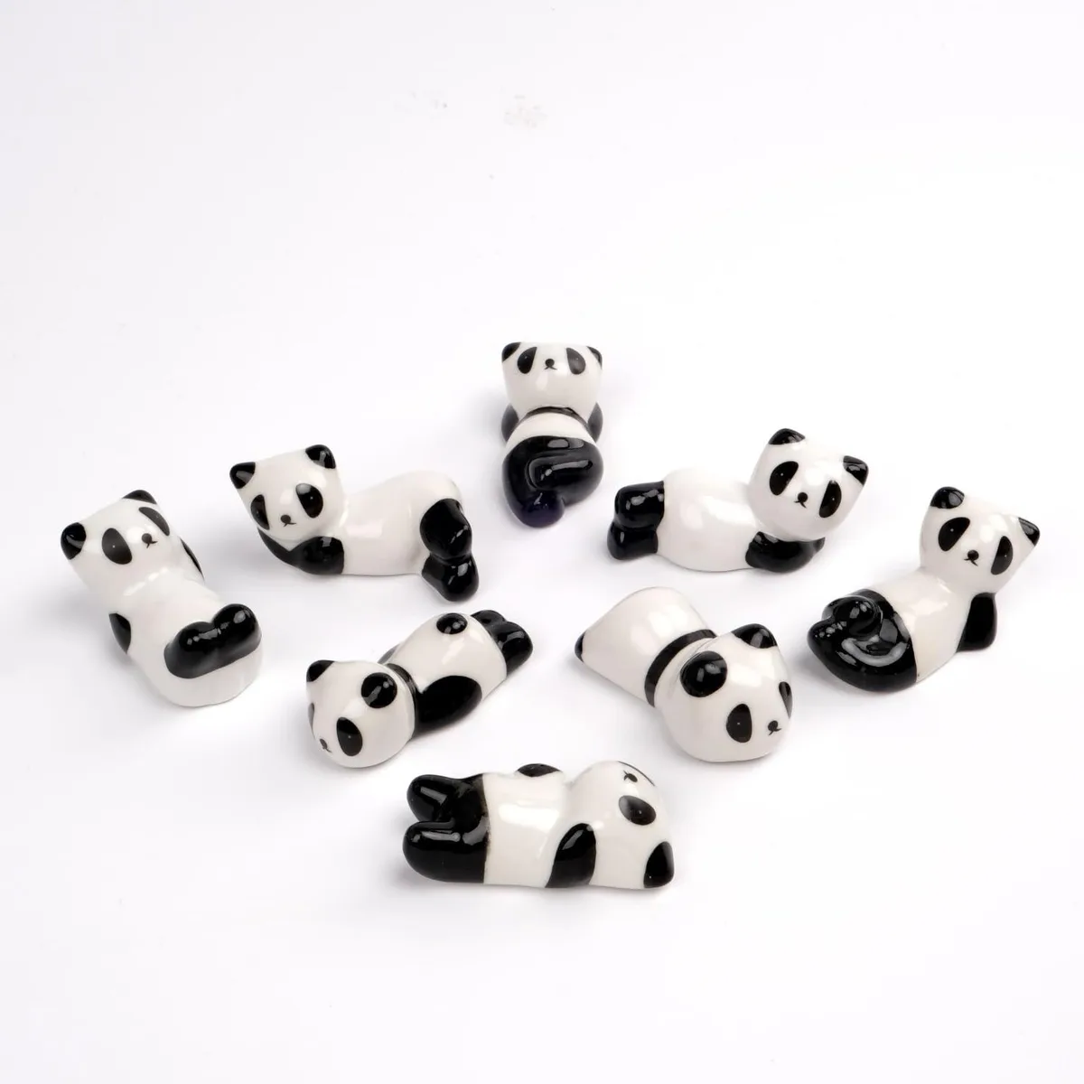 Seven black ceramic panda chopstick rests, glossy finish