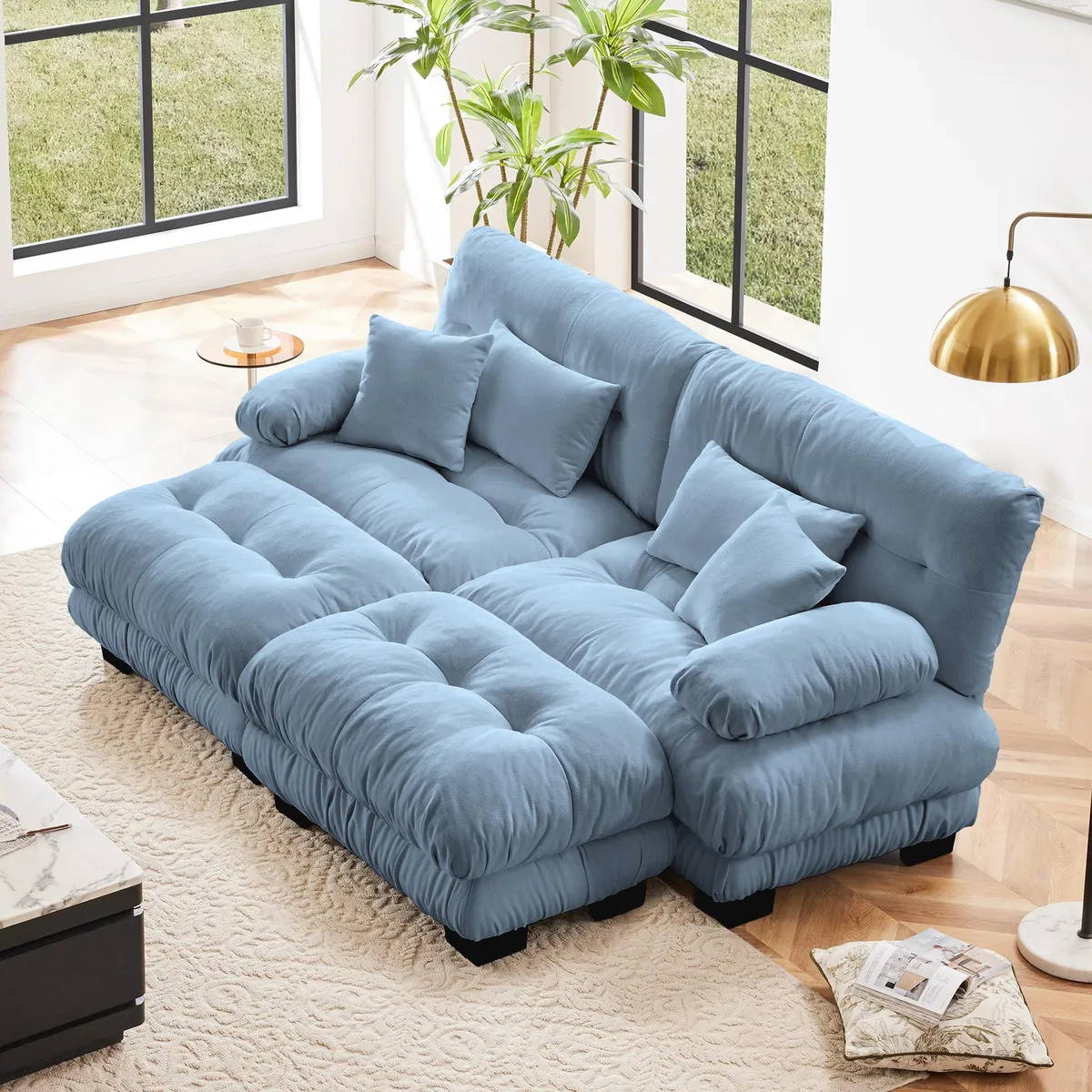 Blue chenille two-seater sleeper sofa with wide bolster arms, two ottomans and four pillows