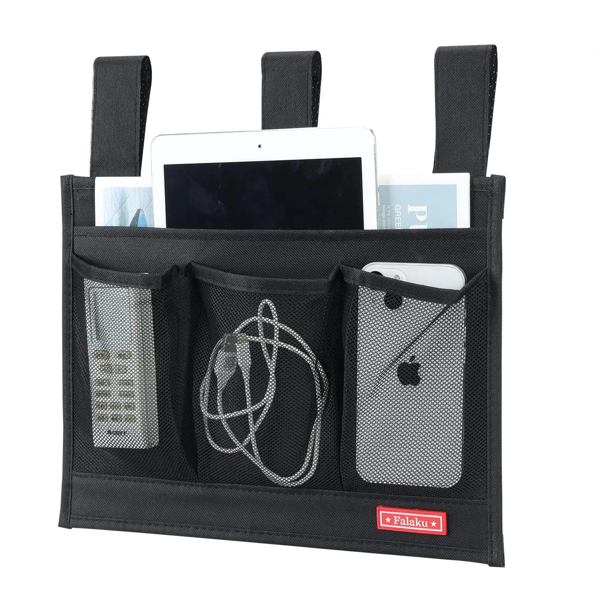 Black fabric bedside caddy with four pockets hanging on bed rail