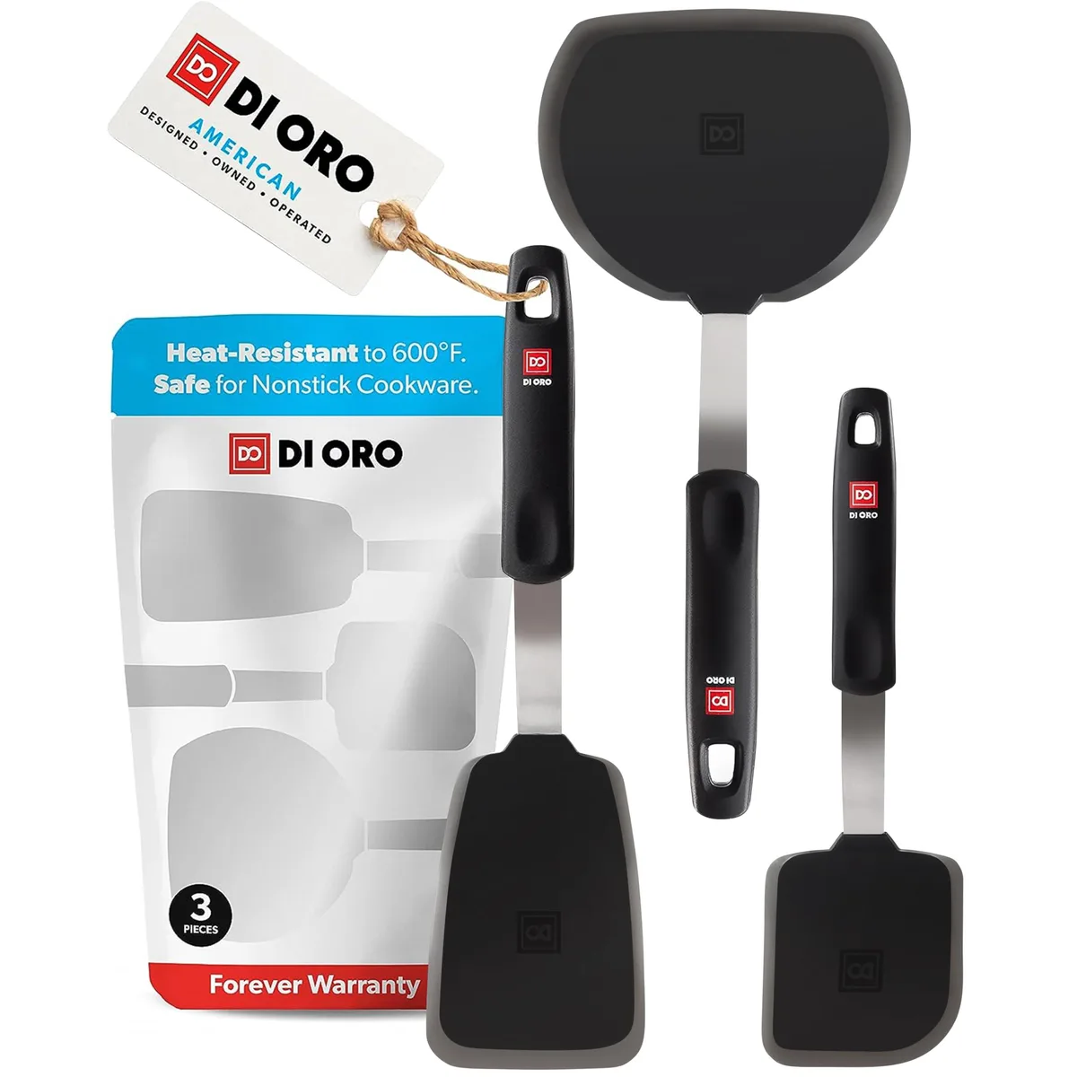 Three black silicone turner spatulas with ergonomic handles on a light surface