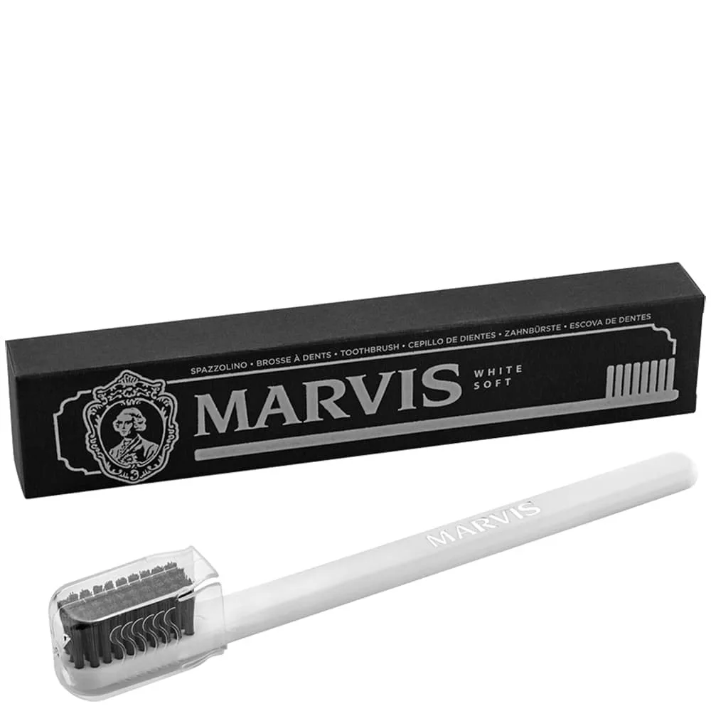 White manual toothbrush with soft bristles, lightweight travel design