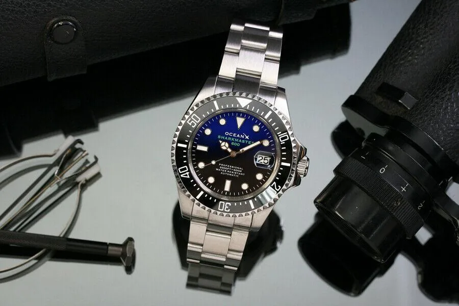 Round 44mm steel diver watch with glossy blue-black gradient dial and black ceramic bezel on steel bracelet