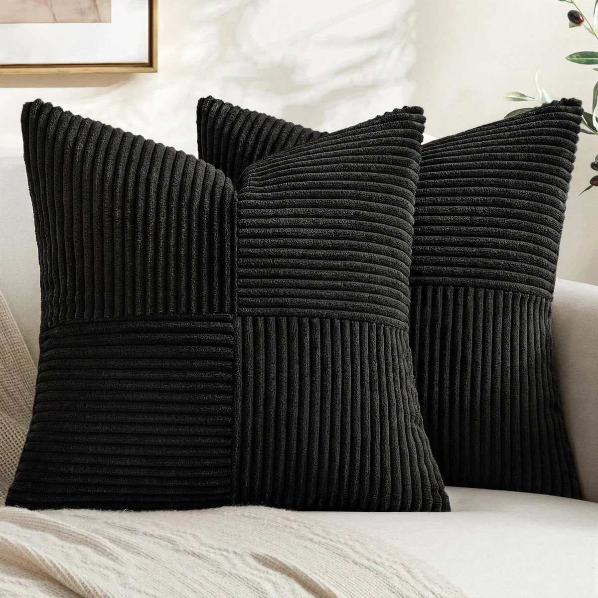 Two square black corduroy pillow covers with cross-stitched front and solid reverse, hidden zipper, 18x18 inch