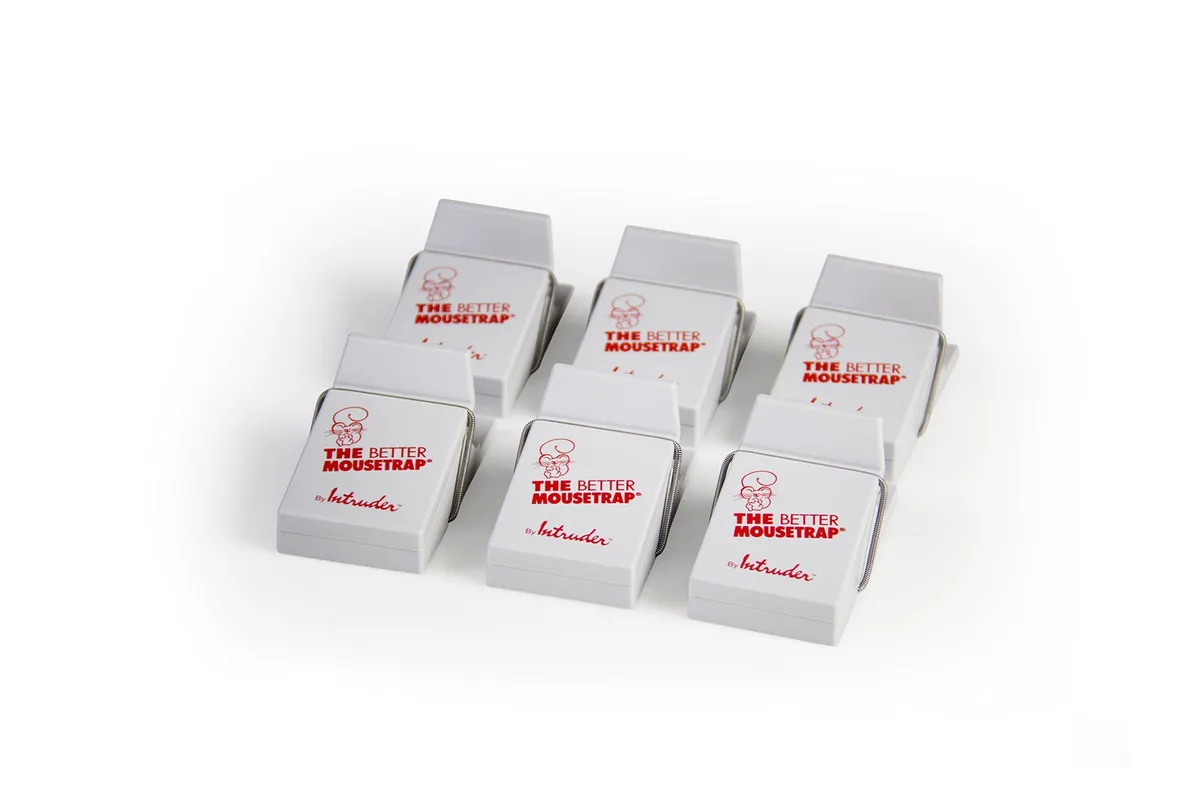 Six white plastic mouse traps in a row