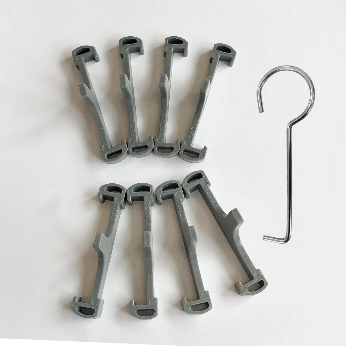 Eight grey plastic clips and a lifting hook for Neodrain 18-72 inch tile drain
