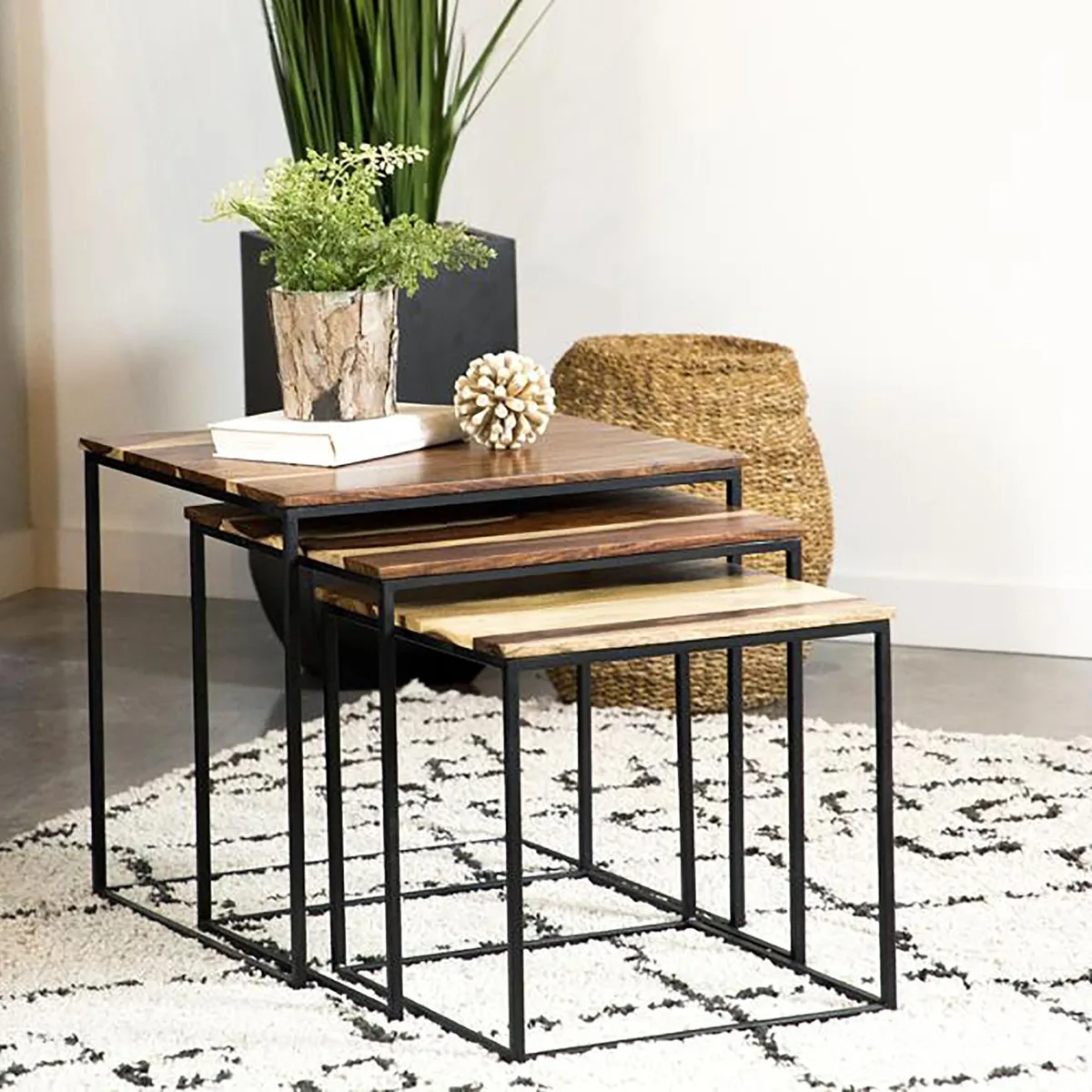 Three rectangular nesting tables with brown sheesham wood tops and slim black metal legs, stacked together