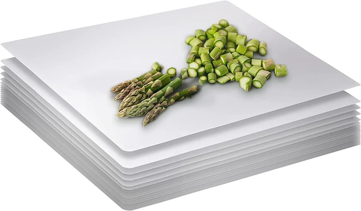 Stack of 15 disposable white plastic cutting boards 10 by 13.5 inches