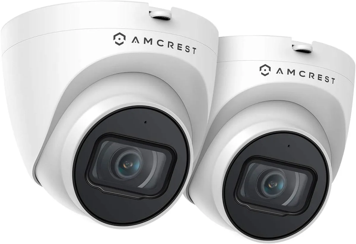 Two white turret cameras cylindrical with flat face and rounded base