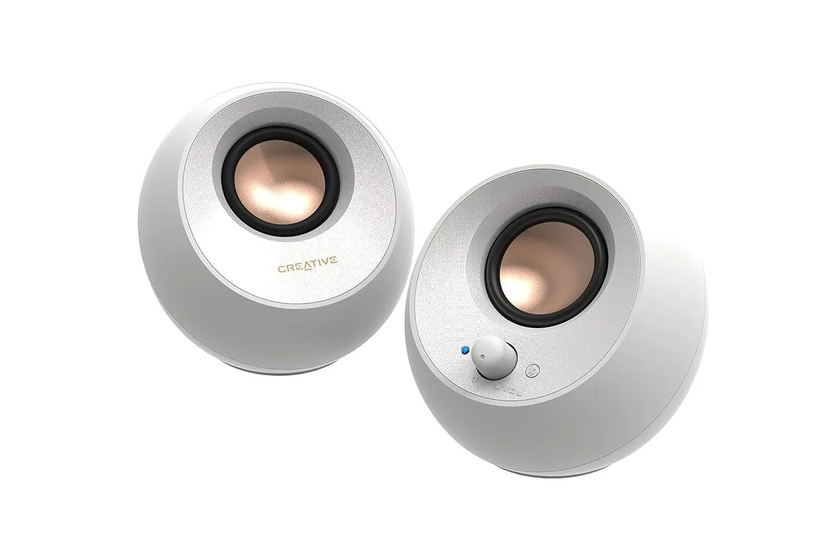 Pair of white spherical desktop speakers on angled stands with single USB-C cable