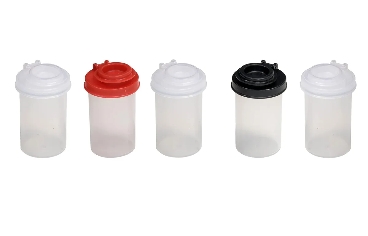 Five clear cylindrical plastic jars with black lids