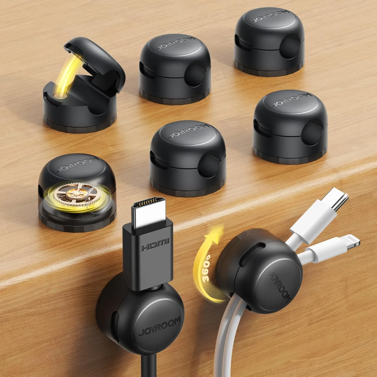 Eight small black square magnetic cable clips with rotating bases on a surface