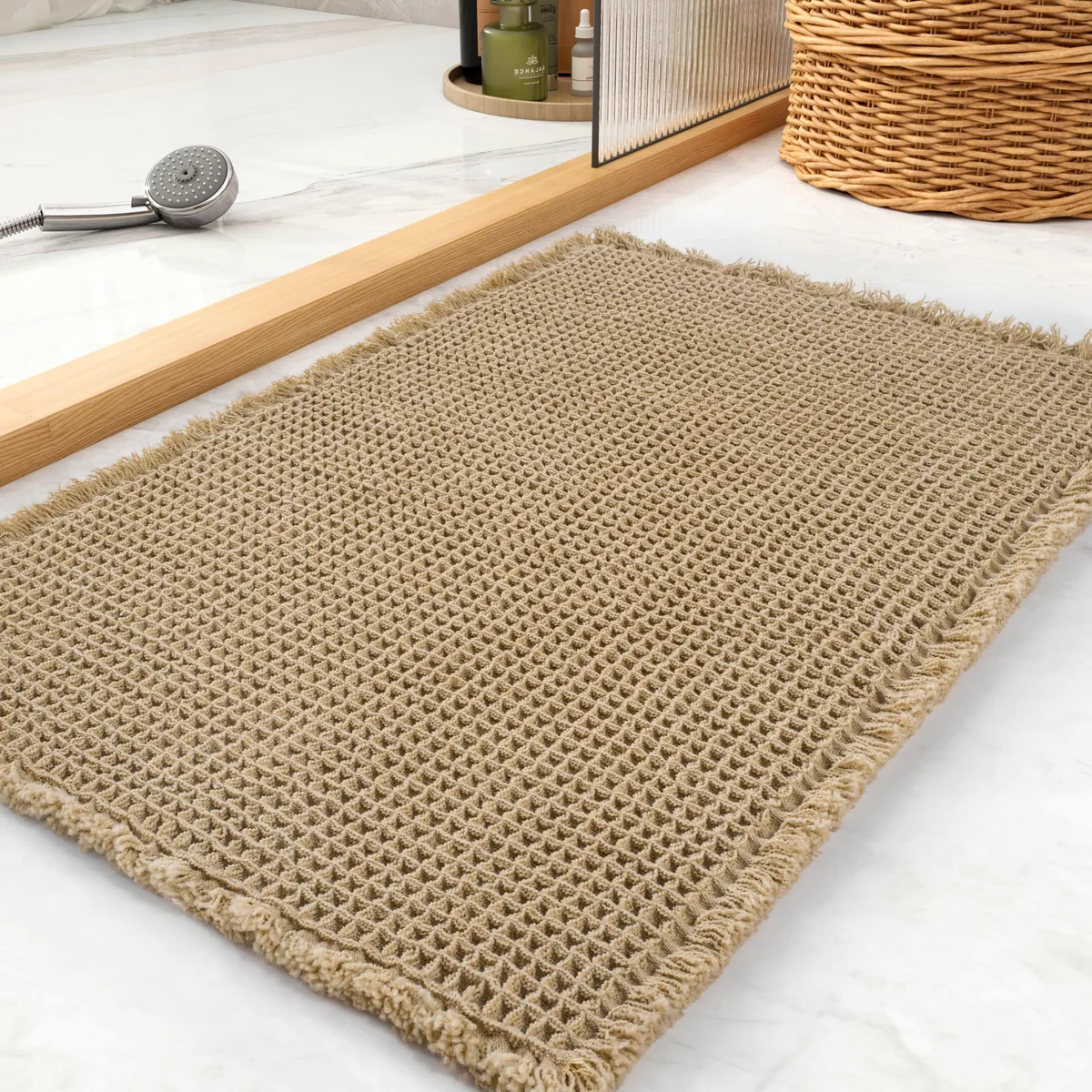 Rectangular brown polyester bath mat with waffle texture and tassels, 17 by 24 inches
