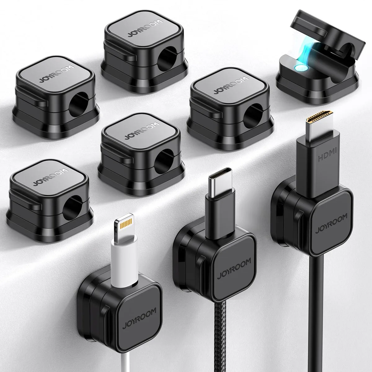 Nine small white plastic clips with adhesive backs and magnetic tops, each about two centimetres long