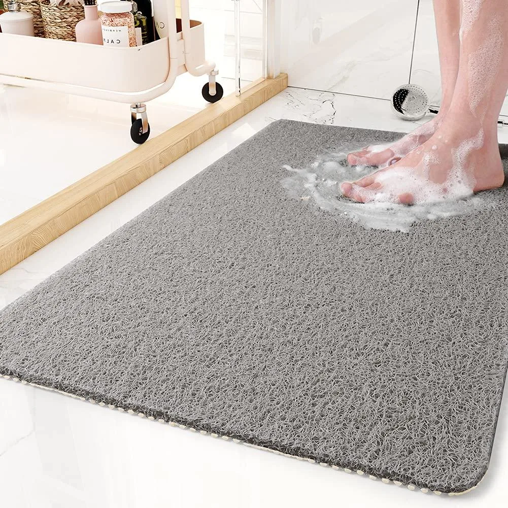 Rectangular PVC bath mat 17 by 30 inches with textured loofah surface and plaid-patterned backing