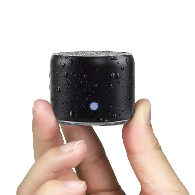 Small black cylindrical Bluetooth speaker with metal hook and carrying case