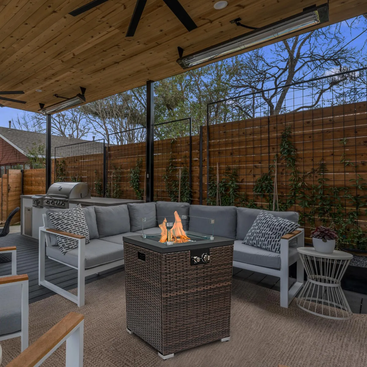 Square black steel fire pit table with dark brown wicker base and glass wind shield