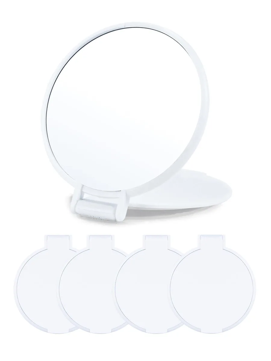 Four small white round mirrors with flip lids lying flat