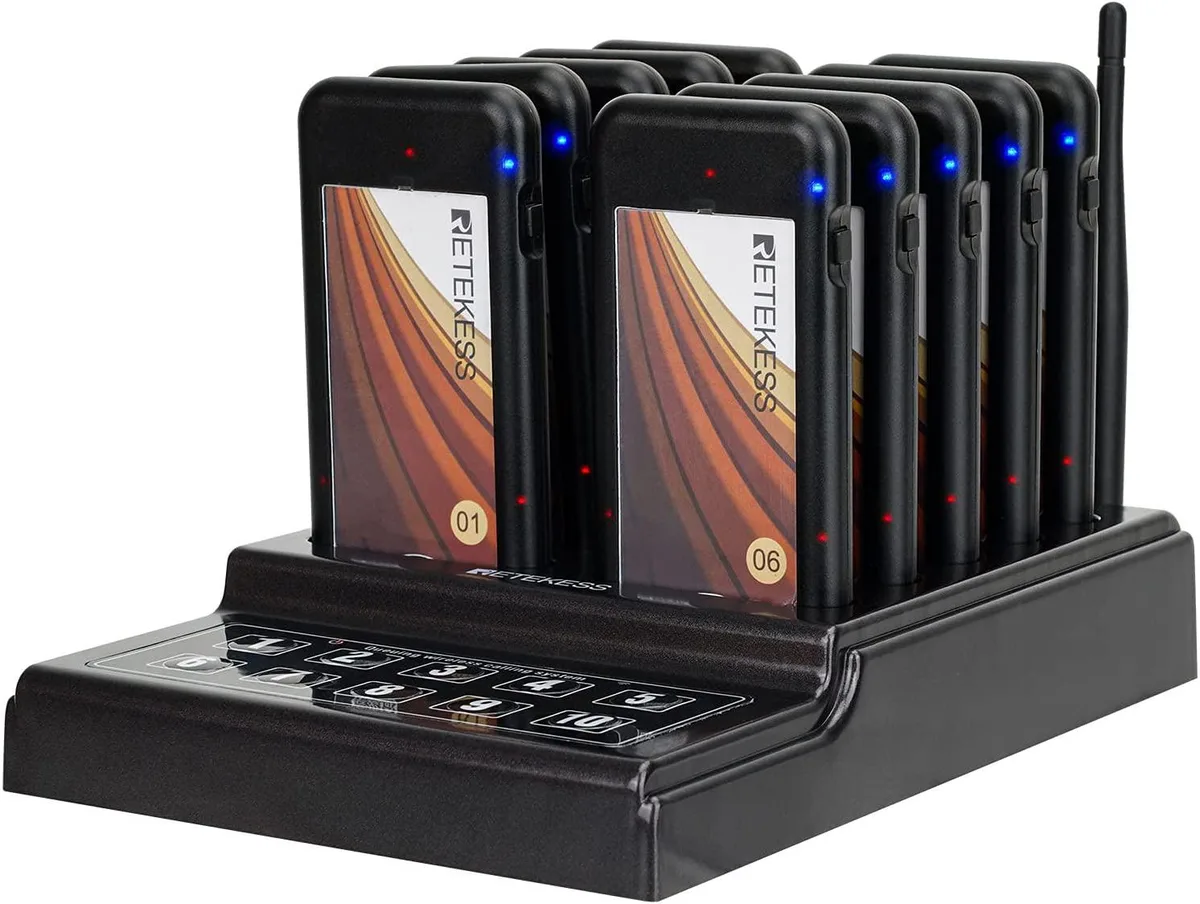 Set of ten white guest pagers with lanyard holes and a black desktop charging base