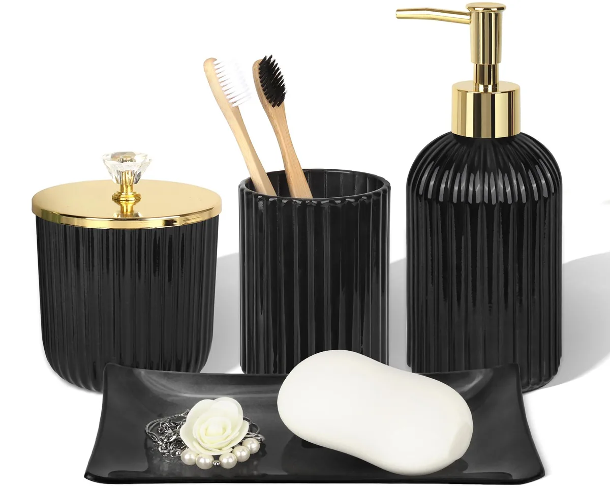 Four-piece black glass bathroom set with stainless steel accents: soap dispenser, toothbrush holder, vanity tray, apothecary jar