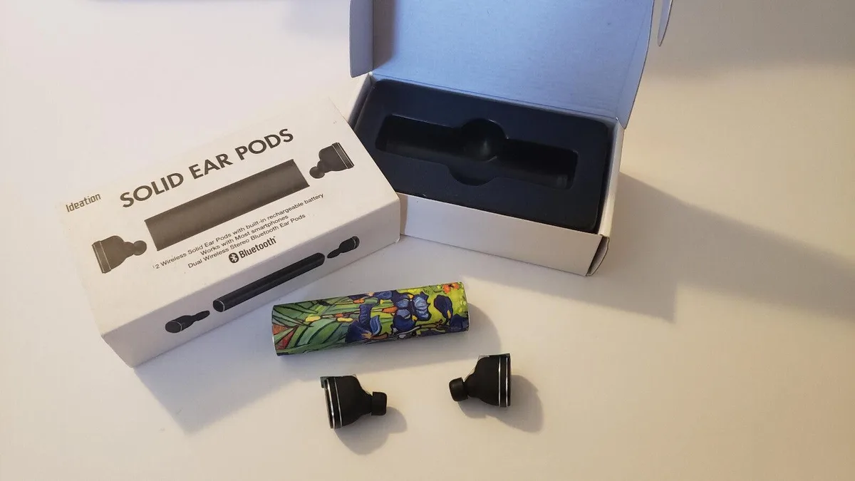 Pair of small wireless ear pods with a compact rectangular charging case