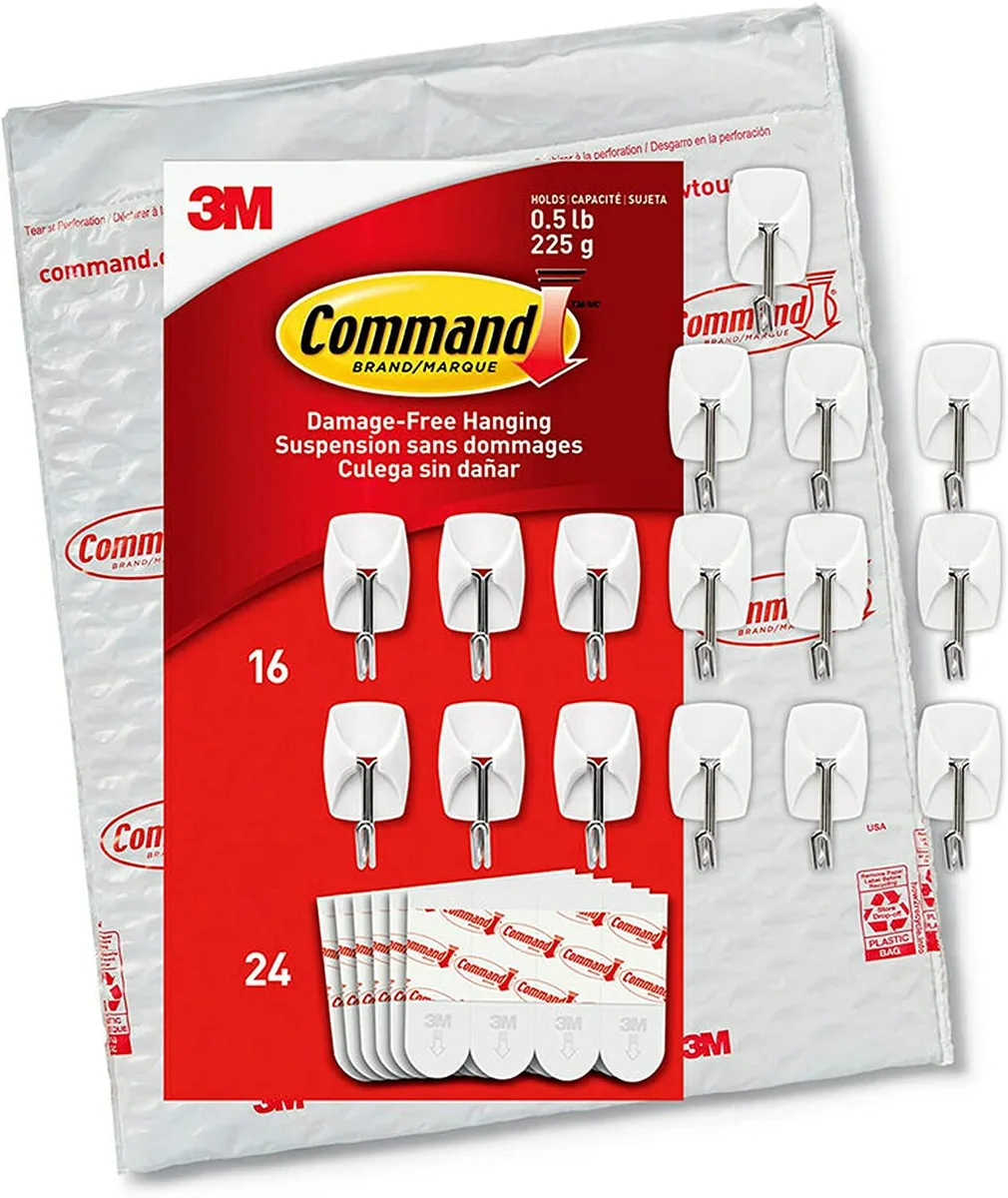 White plastic base with curved metal wire hook, sixteen hooks and twenty-four adhesive strips shown together