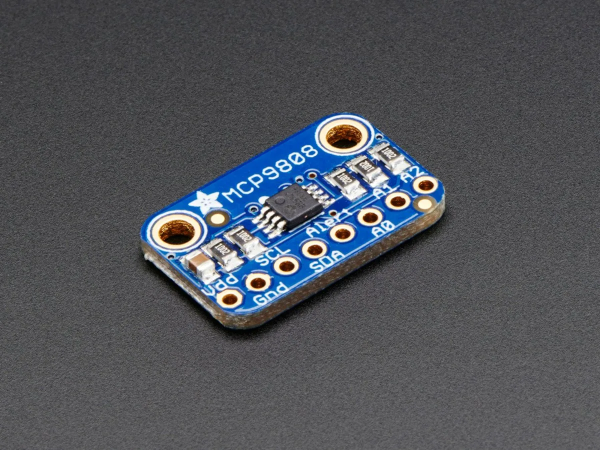 Small green rectangular PCB with surface-mount sensor chip and header pins