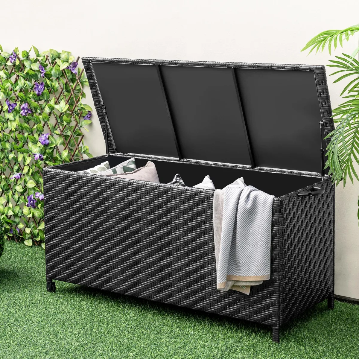 Black rectangular outdoor storage box with woven rattan texture, hinged lid, side handle and wheels