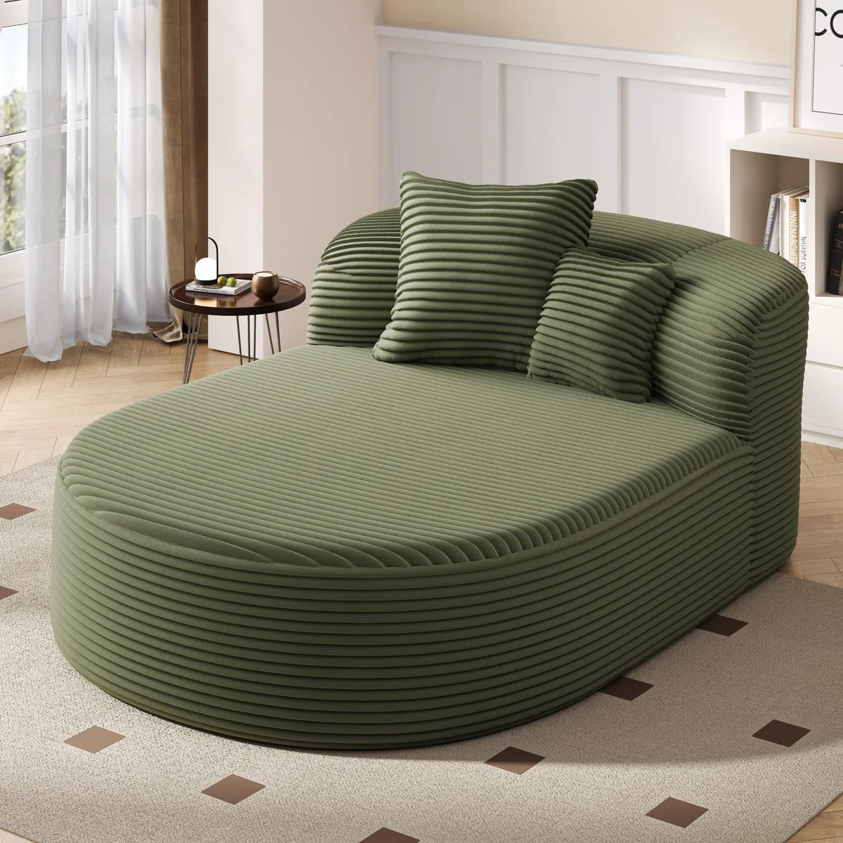 Green corduroy chaise lounge with curved arc silhouette and two throw pillows