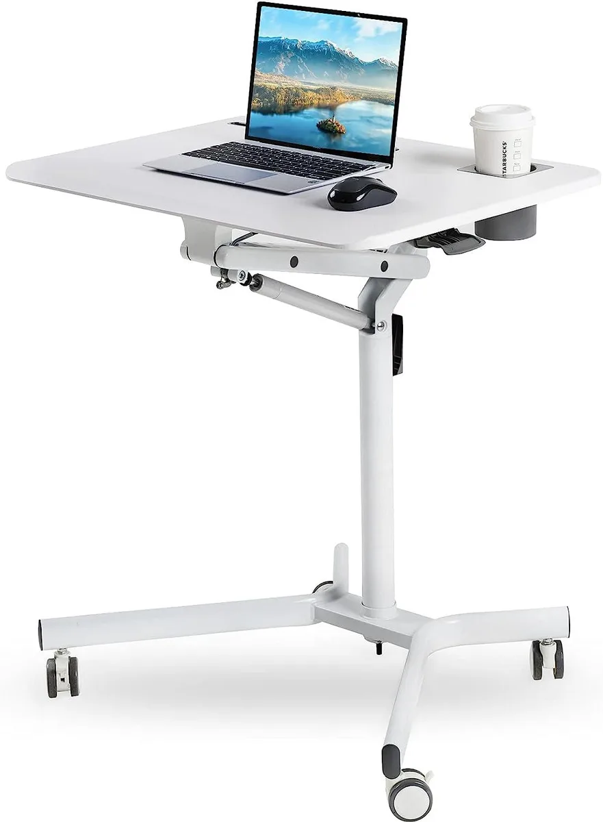 White mobile standing desk on four casters, gas-spring height riser, tilted desktop with tablet slot and cup holder