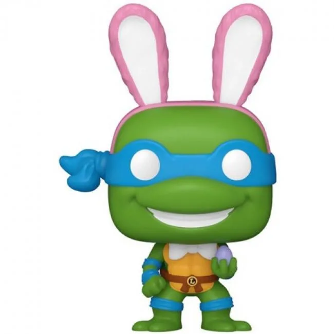 Small green vinyl turtle figure in pastel Easter outfit inside egg-shaped packaging, about 2.15 inches tall