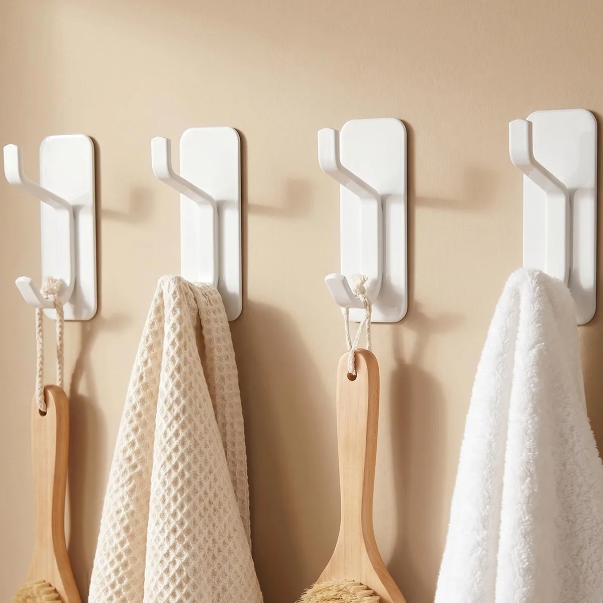 Four white stainless steel double hooks with adhesive backing