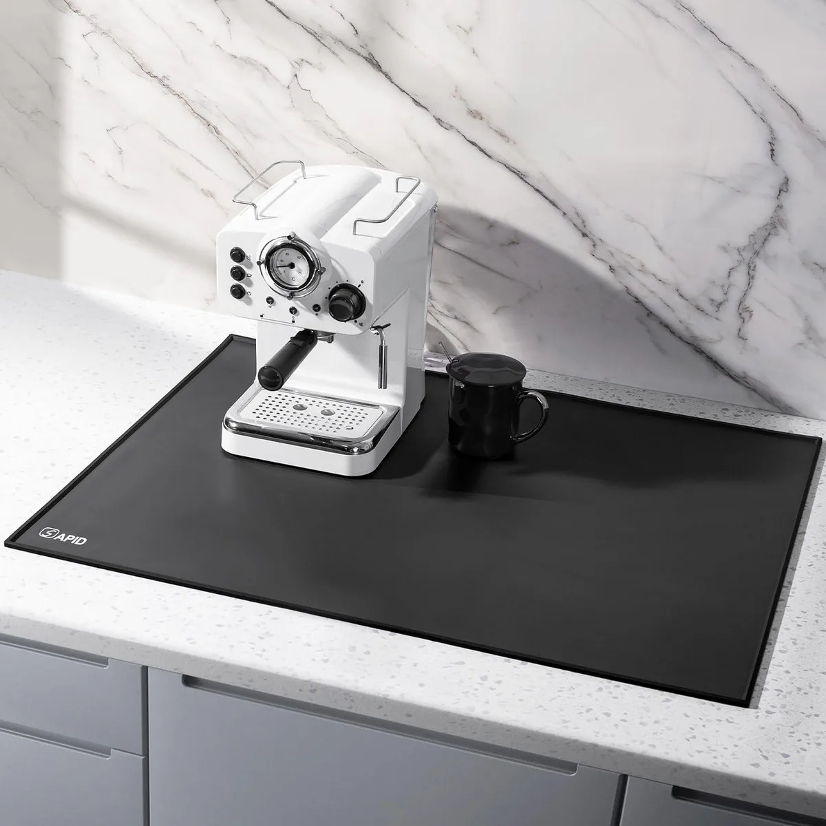 Black rectangular silicone mat with raised lip edges lying flat on countertop