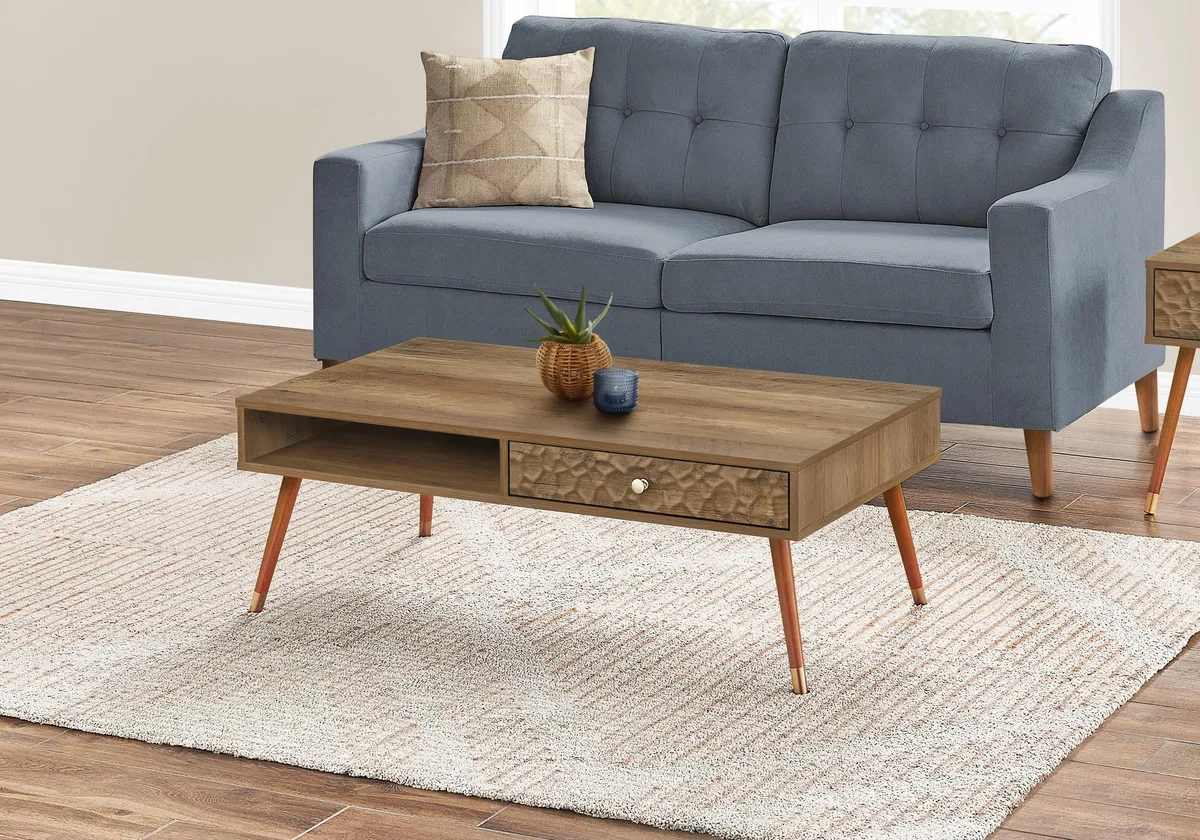 Rectangular walnut laminate coffee table with rippled drawer front, gold metal knob, round solid wood legs with gold detailing