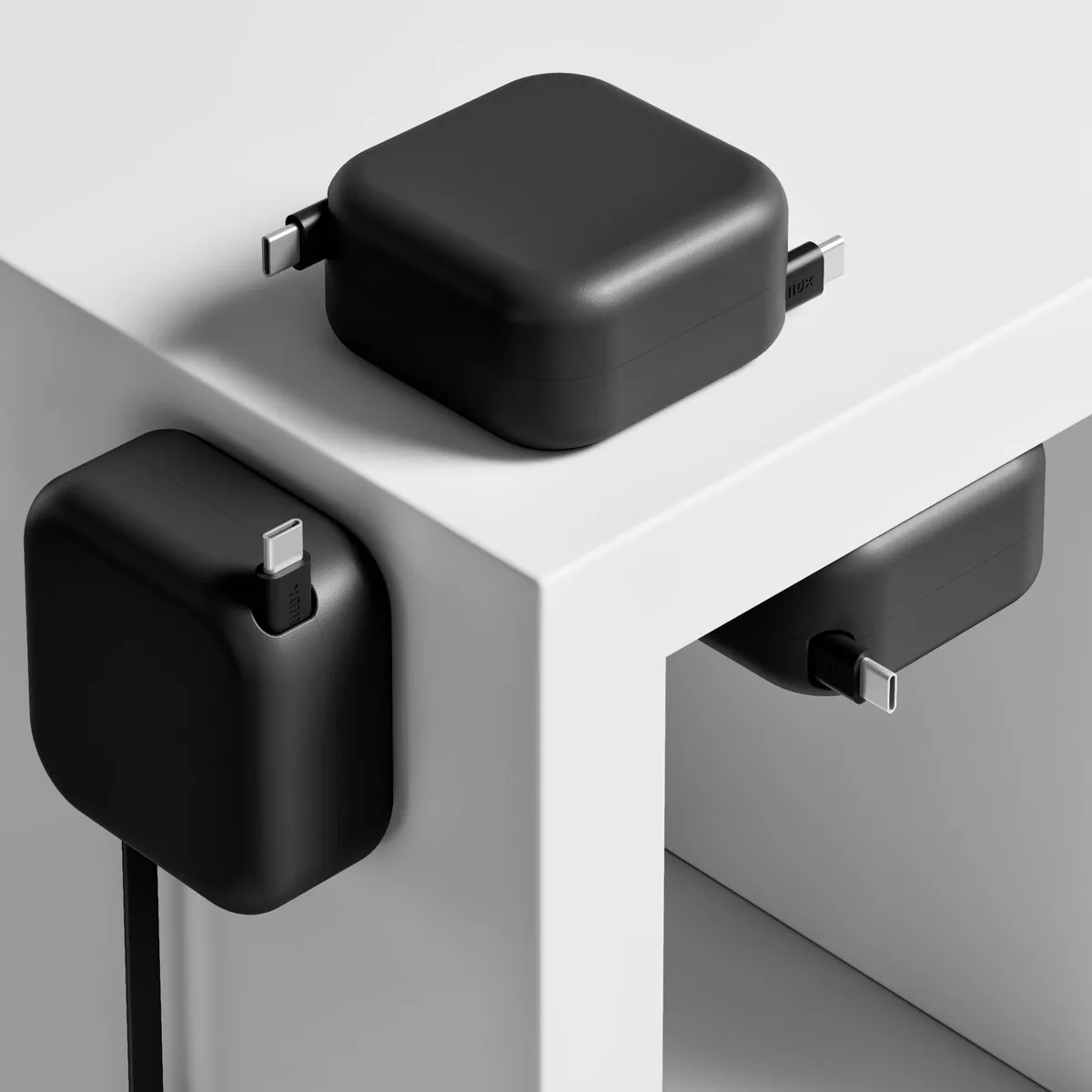 Black retractable USB-C cable in a compact mountable housing with dual independent spools