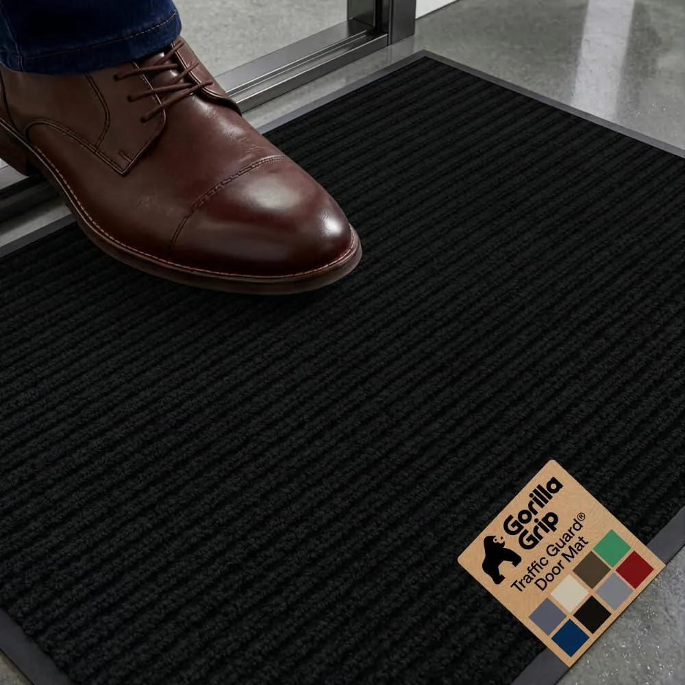 Black rectangular door mat with raised geometric ribs, low-profile rubber backing, 29 by 17 inches